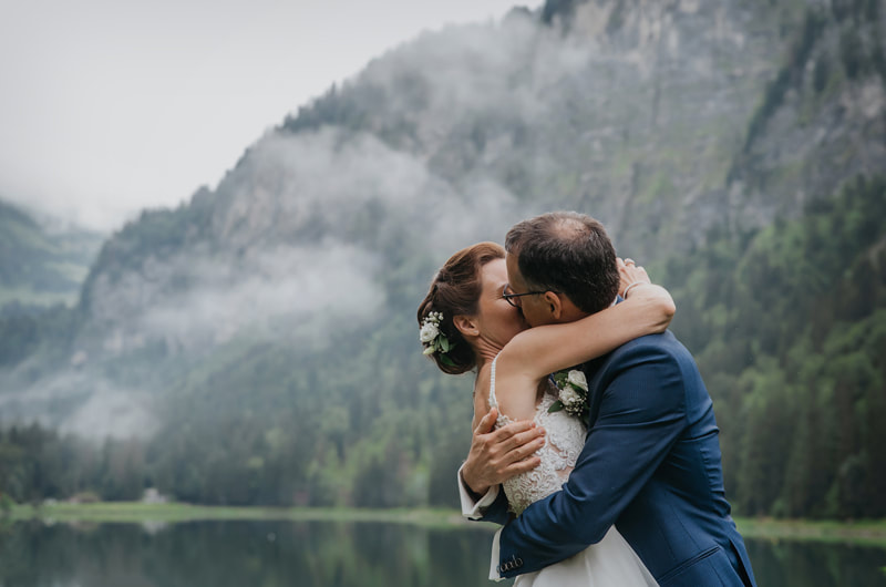 Un couple s'embrasse devant les montagnes au Domaine du Baron en Haute-Savoie

